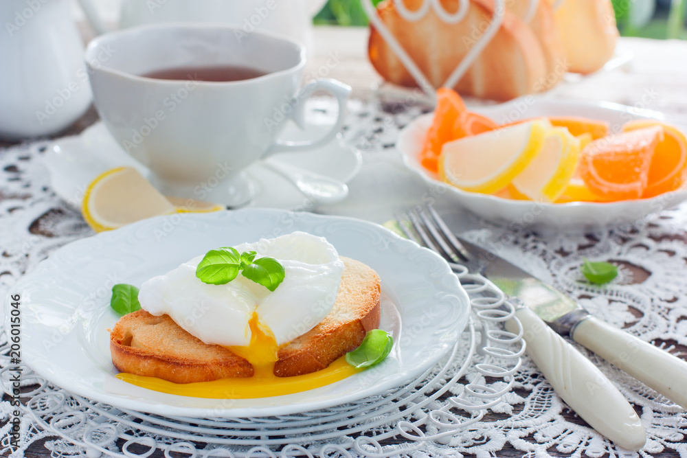 Cut egg-poached on a toast on a white plate, horizontal Cut egg-poached on a toast on a white plate, horizontal