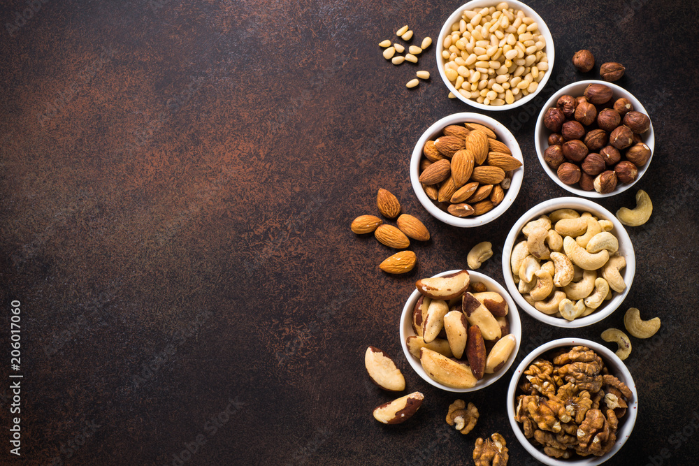 Fototapeta premium Nuts assortments on stone table top view.