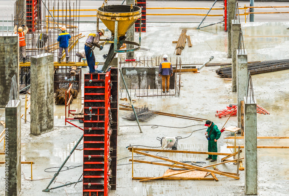 Construction workers are working on a construction site in Kiev, Ukraine. Concrete construction works and assembly of metal structures are carried out.