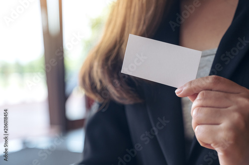A businesswoman holding and showing an empty business card