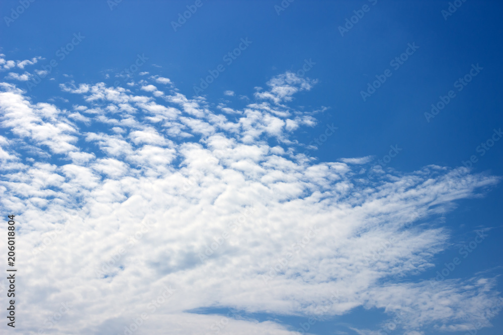 Fototapeta premium Fluffy white clouds on a blue sky. Clear sunny day. Background.