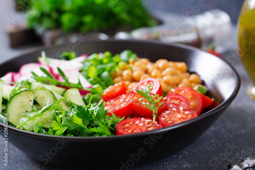 Salad of chickpeas, tomatoes, cucumbers, radish and greens. Dietary food. Buddha bowl. Vegan salad.