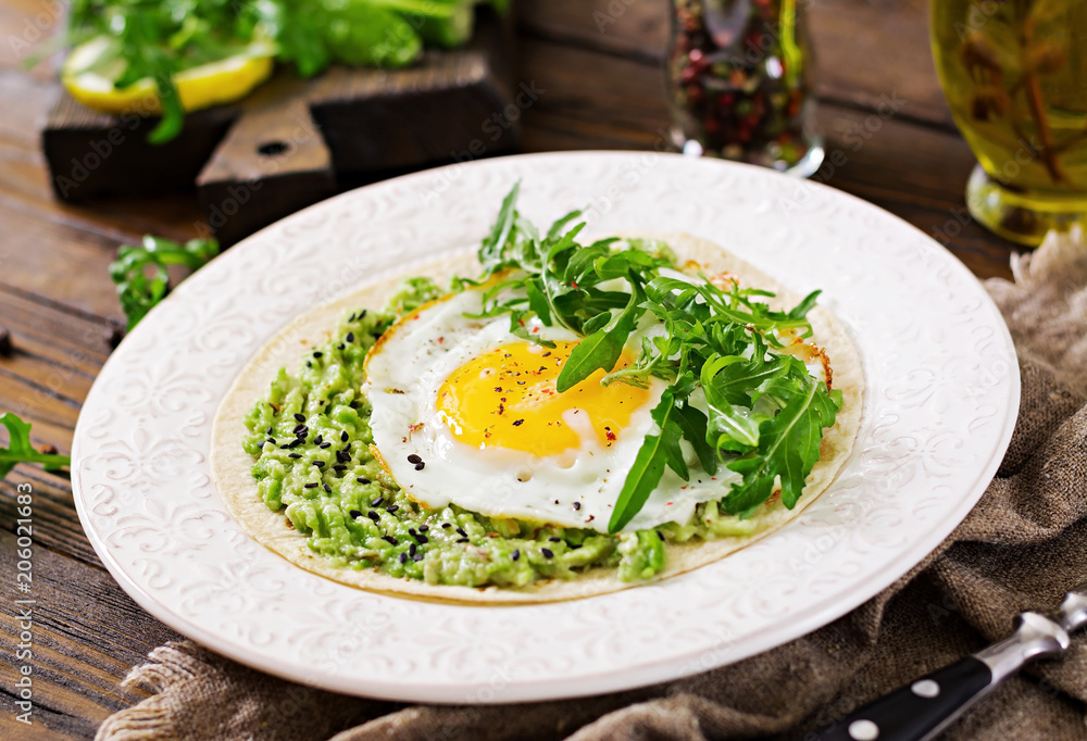 Tacos with guacamole, fried egg and arugula. Healthy food. Useful breakfast. Tacos with guacamole, fried egg and arugula. Healthy food. Useful breakfast.
