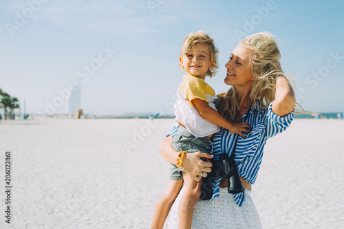 Young mother and happy little son at sandy beach in Dubai, UAE