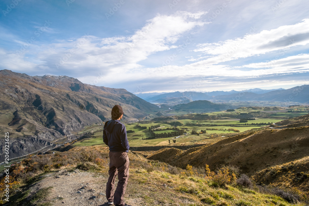 A young Asian man enjoying with a stunning scenery on the high mountain before sunset.