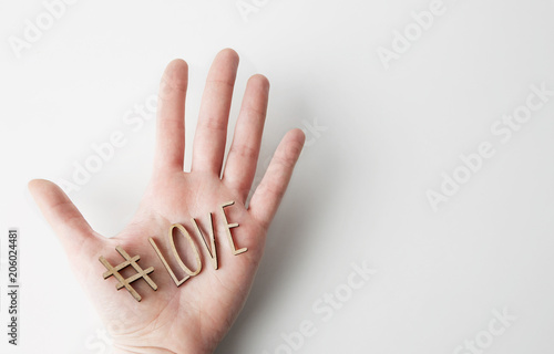 Mockup of love message with wooden letters on male hand on empty white background. Business mock-up background for message writing.Top view