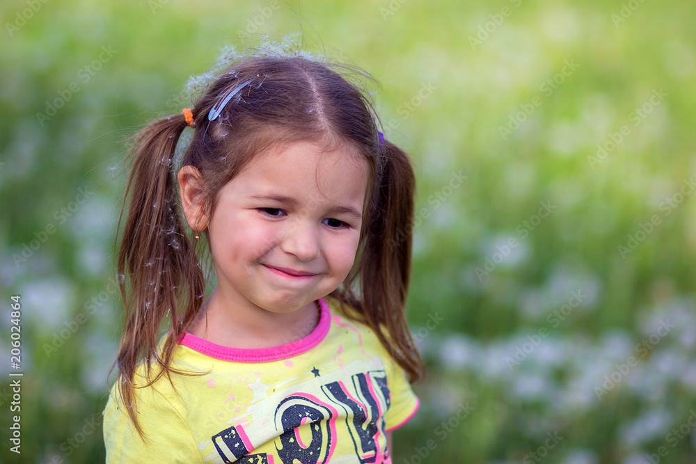 The girl on a prroda with fuzzes from dandelions on the head The girl on a prroda with fuzzes from dandelions on the head