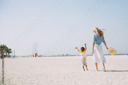 Canvas Print Young mother and happy little son at sandy beach in Dubai, UAE
