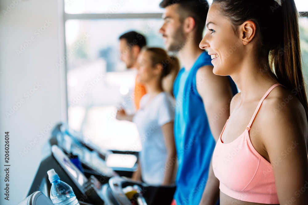 Healthy man and woman running on a treadmill in a gym Healthy man and woman running on a treadmill in a gym