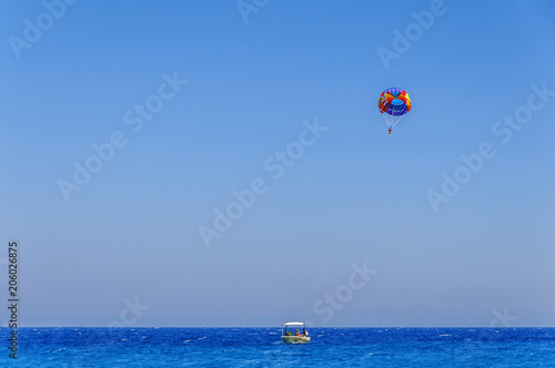 Parachute skiing on blue wave sea and big clean sky