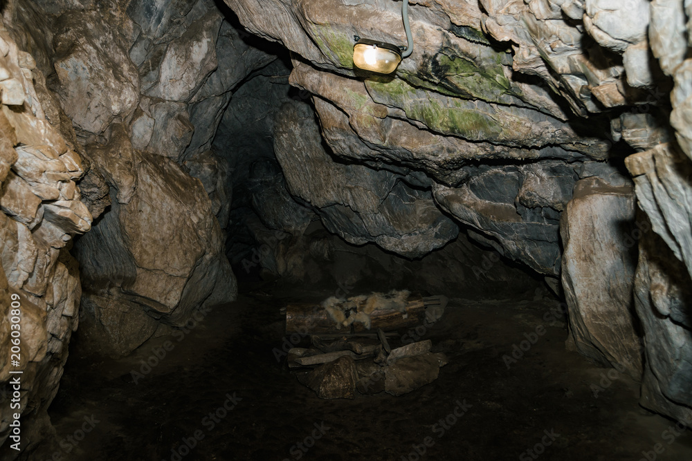 Beautiful cave. View from inside dark dungeon. Textured walls of cave. Background image of underground tunnel. Dampness inside cave. Dwelling of primitive cave people.