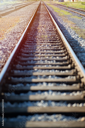 Straight Railroad track against sunshine. Shallow depth of field.