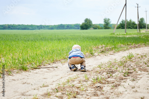 child is playing on a country road in a field