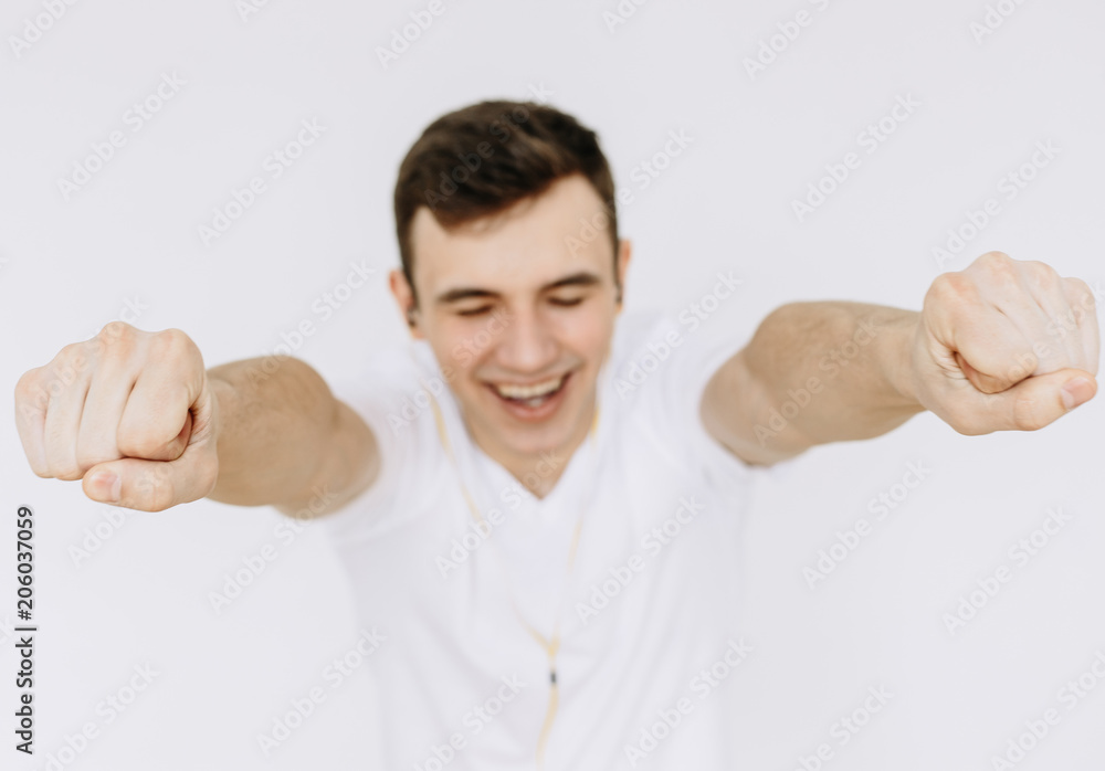 The young guy extends his arms forward and smiles. Іsolated white background The young guy extends his arms forward and smiles. Іsolated white background