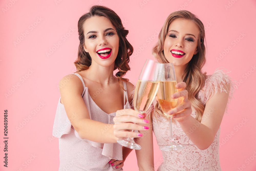 Two cheerful women in dresses drinking champagne Two cheerful women in dresses drinking champagne