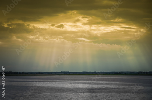 Sun rays penetratinging through the clouds over the lake. photo