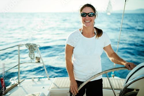 Attractive strong woman sailing with her boat