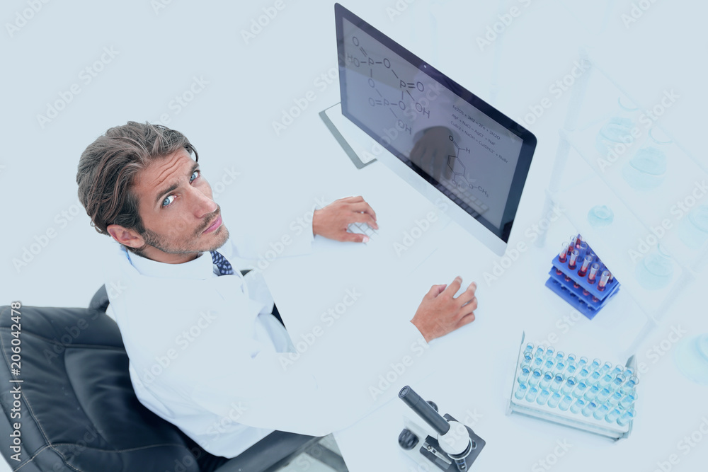view from above of the scientist-doctor sitting on the computer. view from above of the scientist-doctor sitting on the computer.