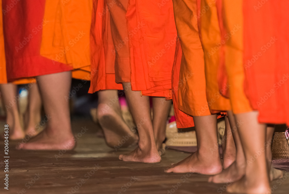The feet of monks close-up. Feeding the monks. The ritual is called Tak Bat, Luang Prabang, Laos.