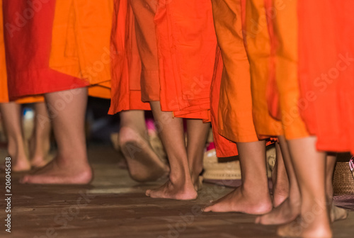 The feet of monks close-up. Feeding the monks. The ritual is called Tak Bat, Luang Prabang, Laos. © ggfoto