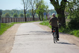 a man is riding a bicycle on a country road