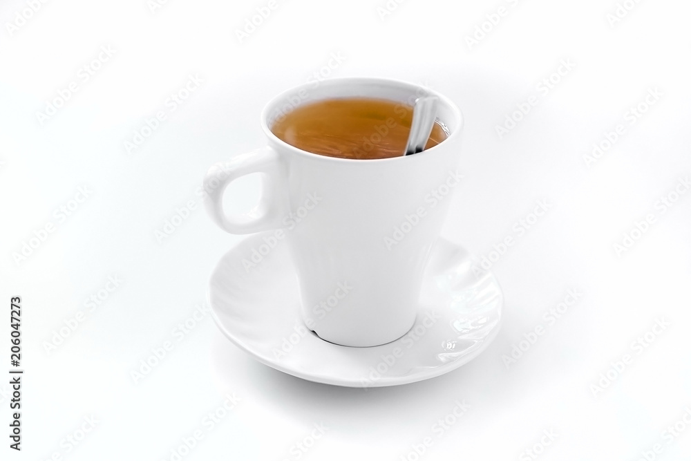 a full cup of brewed black tea with a saucer and a spoon on a white table a full cup of brewed black tea with a saucer and a spoon on a white table