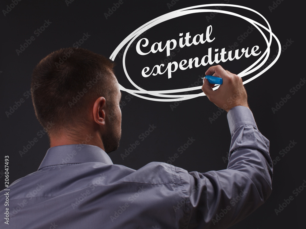 The concept of business, technology, the Internet and the network. Young businessman showing inscription: Capital expenditure The concept of business, technology, the Internet and the network. Young businessman showing inscription: Capital expenditure