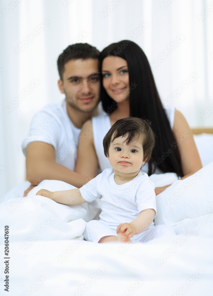 Portrait of a joyful family sitting on the bed at home Portrait of a joyful family sitting on the bed at home
