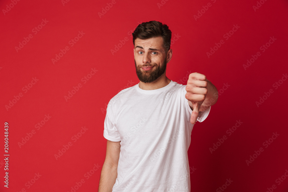 Sad young man showing thumbs down Sad young man showing thumbs down