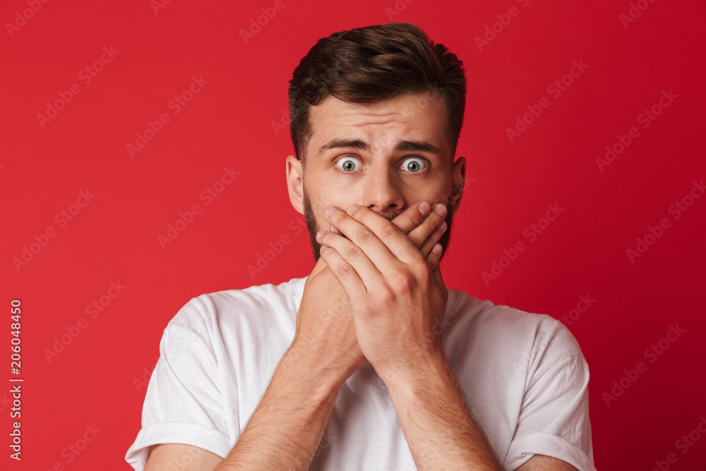 Scared young man covering mouth with hands Scared young man covering mouth with hands