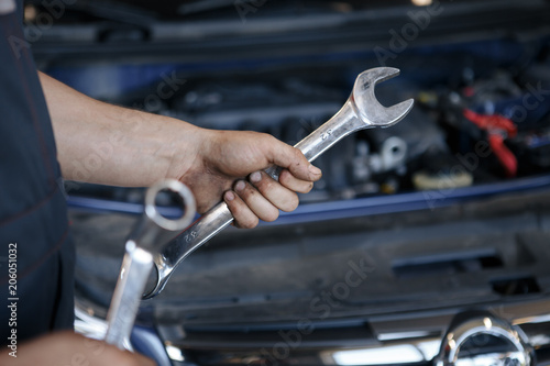 Wallpaper Mural Hand of car mechanic with wrench. Auto repair garage. Torontodigital.ca