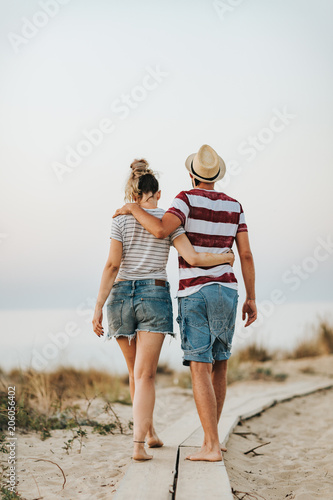 Young loving couple walking on the beach. Back view