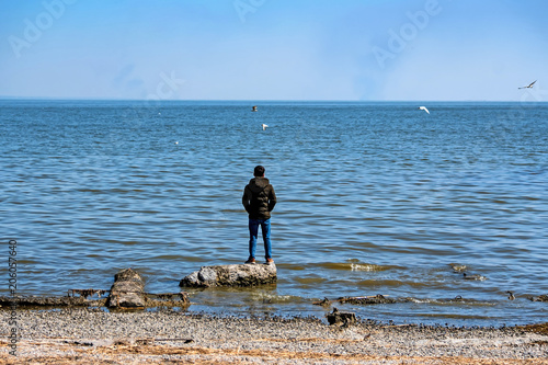 Single young man looks at sea in autumn