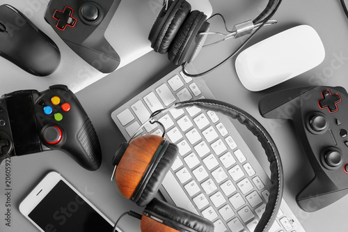 Gamepads, mice, headphones and keyboard on table photo