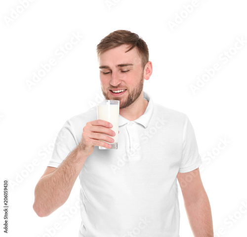 Young man drinking tasty milk on white background