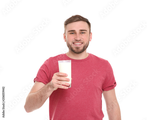 Young man with glass of tasty milk on white background