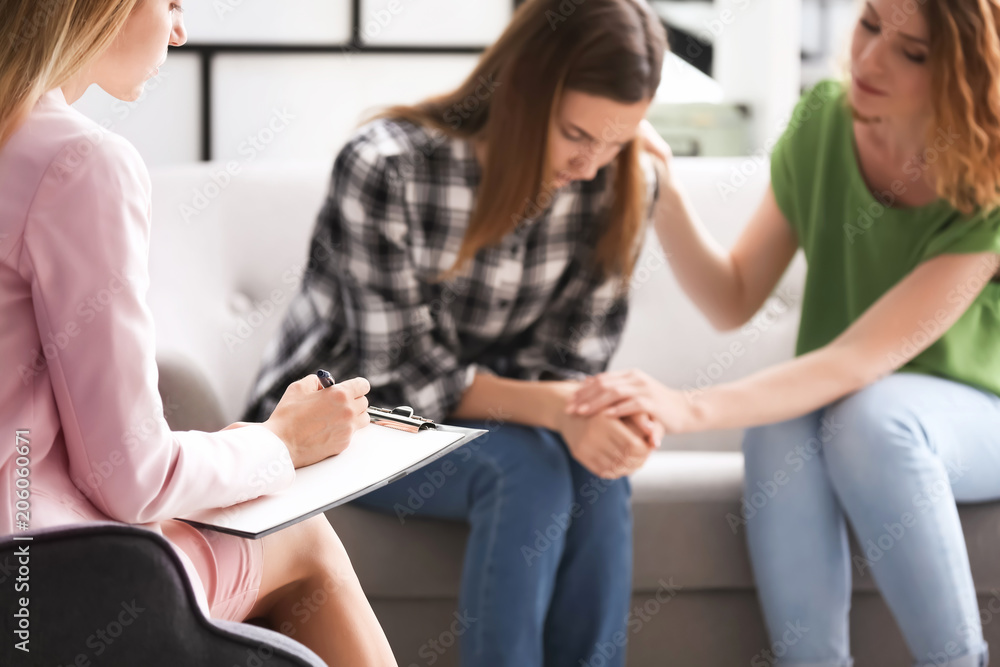 Φωτογραφία Young woman and her teenage daughter visiting child psychologist in office