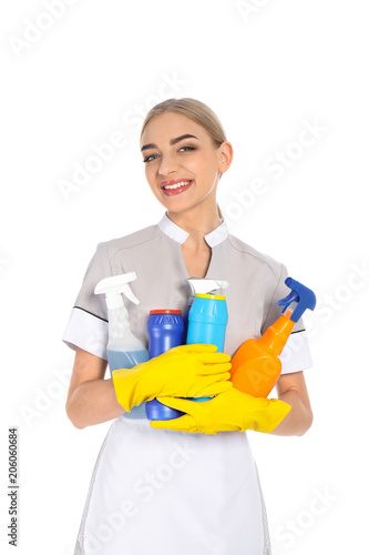 Young chambermaid with detergents on white background