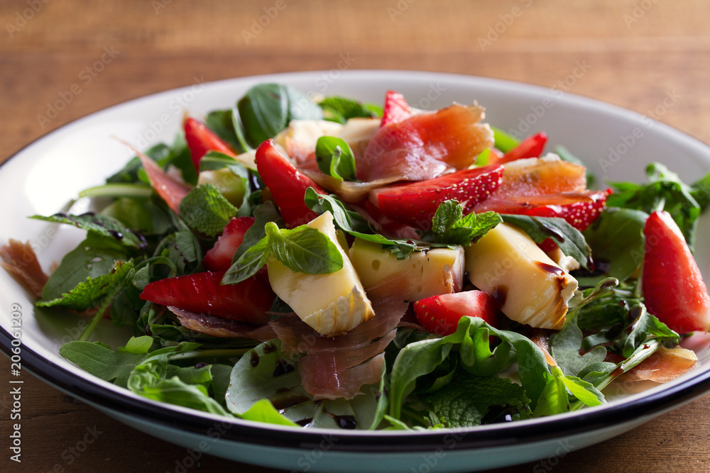 Strawberry, avocado, basil, mint, arugula salad with brie cheese and jamon or prosciutto. Healthy salad bowl Strawberry, avocado, basil, mint, arugula salad with brie cheese and jamon or prosciutto. Healthy salad bowl