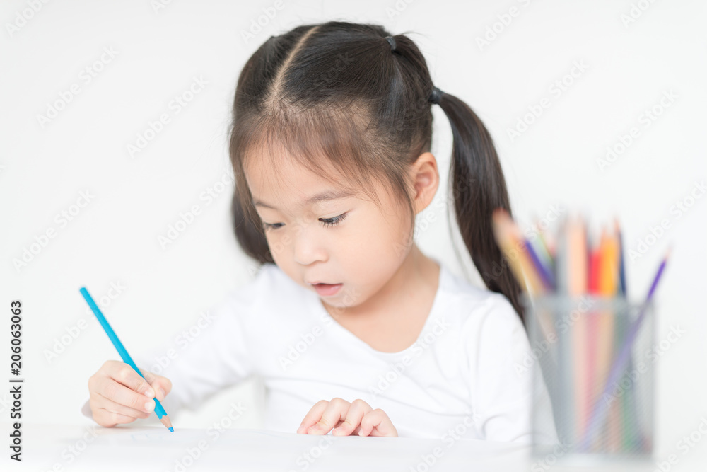 Pretty girl is painting on her homework. Cute girl working on her school project at home. Pretty girl is painting on her homework. Cute girl working on her school project at home.