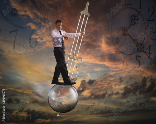 Businessman standing on a pendulum of a grandfather clock swinging in the air on twilight background in concept of tight schedule. photo