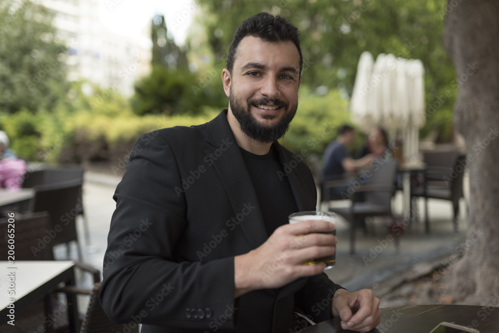 Man drinking beer in bar terrace looking at camera Man drinking beer in bar terrace looking at camera