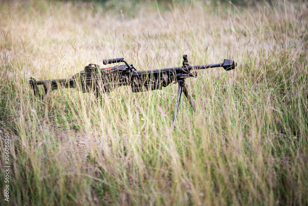 Machine gun on tripod and hidden at field. Machine gun on tripod and hidden at field.
