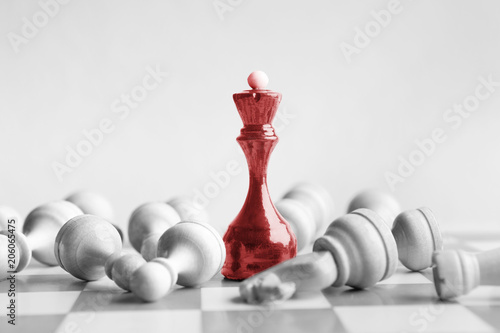 Black chess queen beats whites on chessboard