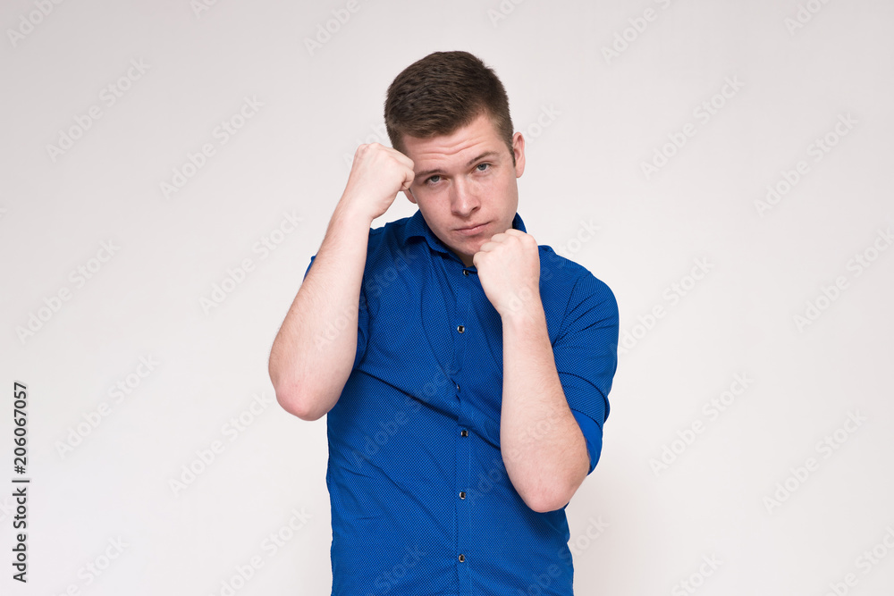 Portrait of a young handsome man on a white background and ready to fight. Portrait of a young handsome man on a white background and ready to fight.