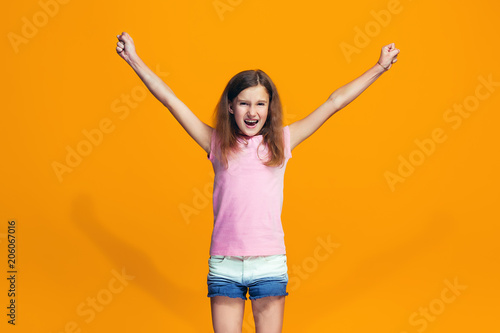 Happy success teen girl celebrating being a winner. Dynamic energetic image of female model