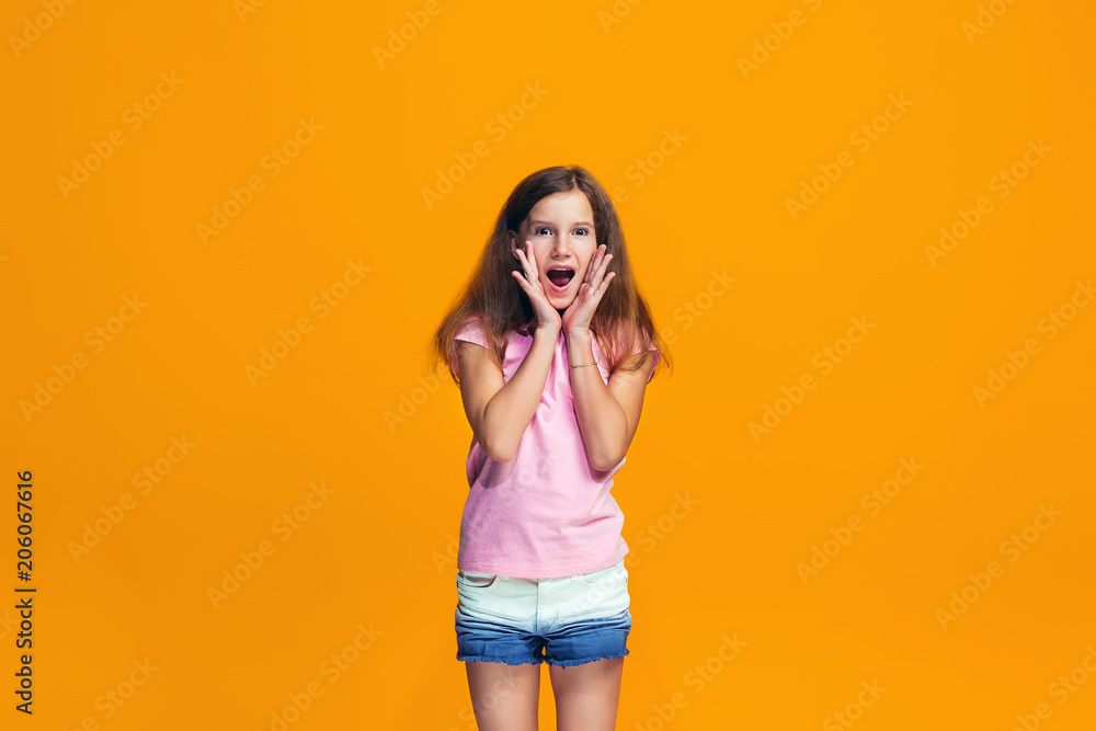 Beautiful teen girl looking suprised isolated on orange Beautiful teen girl looking suprised isolated on orange
