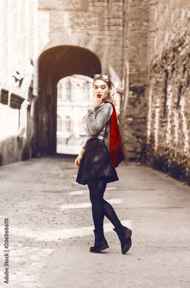 beautiful blonde is standing on city streets. stylish and sexually dressed. skirt. red lipstick on lips