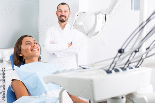 Young female is sitting satisfied after treatment in dental office