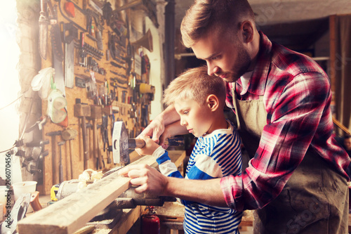 Tapeta family, carpentry, woodwork and people concept - father and little son with hamm